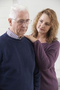 caregiver with hand on shoulder of elderly dementia patient