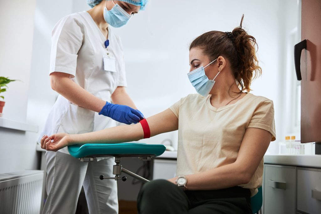 A phlebotomist getting ready to take a patient's blood